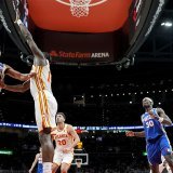 Clint Capela (au centre) tente de s'interposer face à Quentin Grimes. KEYSTONE/AP/Mike Stewart